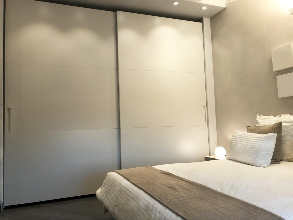 Modelo de dormitorio tipo loft moderno de tamaño medio sin chimenea con paredes beige, suelo de linóleo y suelo gris