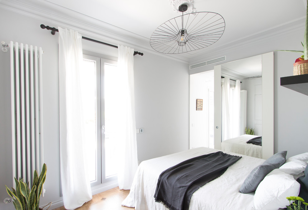 ミラノにある中くらいなコンテンポラリースタイルのおしゃれな主寝室 (グレーの壁、無垢フローリング、漆喰の暖炉まわり、茶色い床)