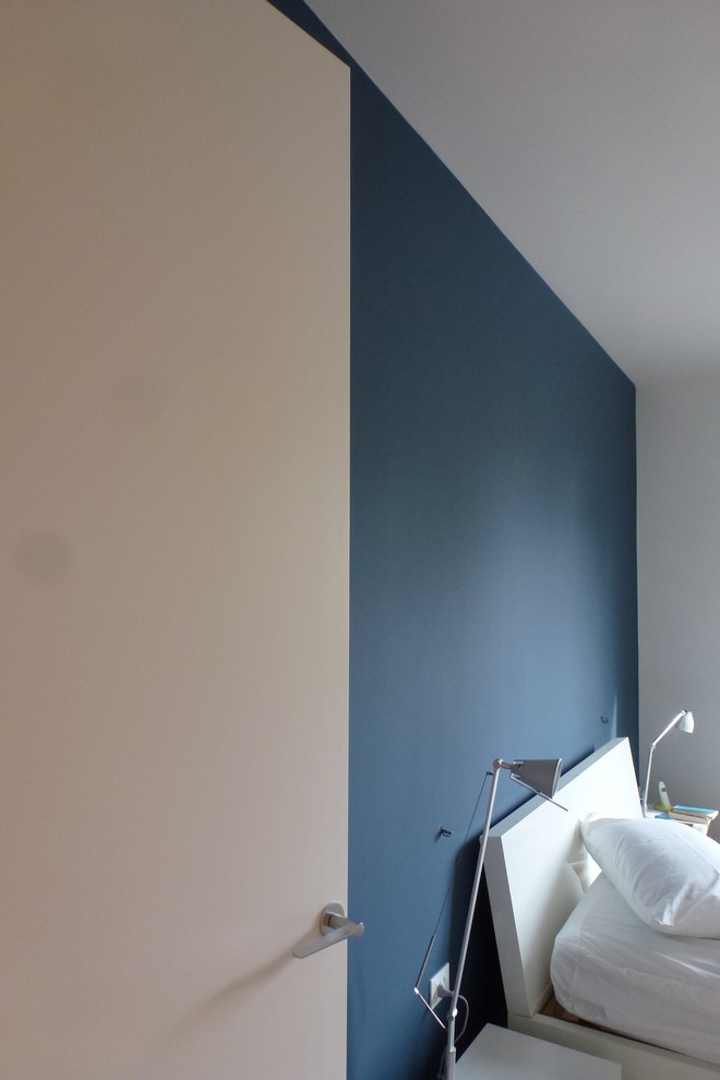 Foto di una camera matrimoniale contemporanea di medie dimensioni con pareti blu, pavimento in legno verniciato, nessun camino e pavimento marrone