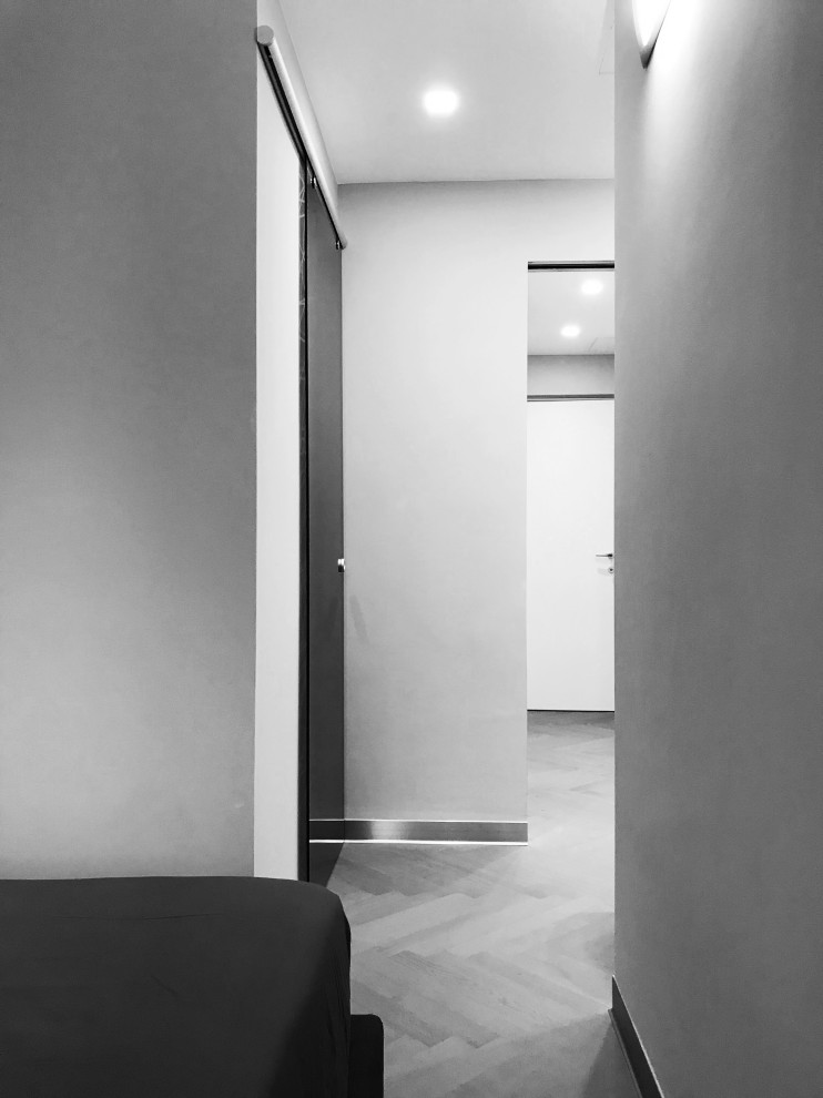 Großes Modernes Hauptschlafzimmer mit weißer Wandfarbe, braunem Holzboden und braunem Boden in Mailand