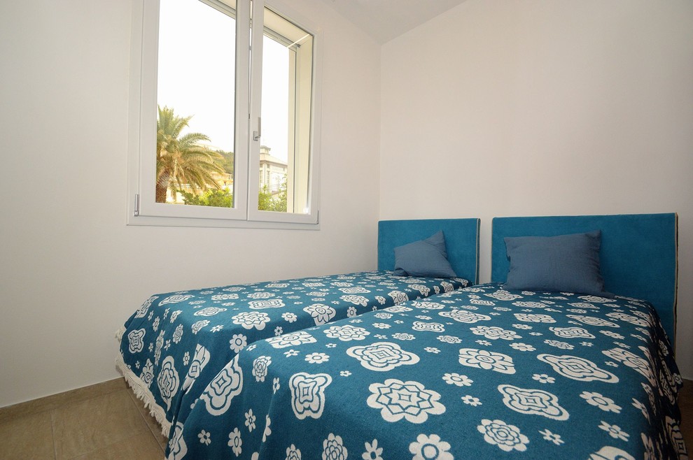 Esempio di una piccola camera matrimoniale minimalista con pareti bianche, pavimento in gres porcellanato e pavimento beige