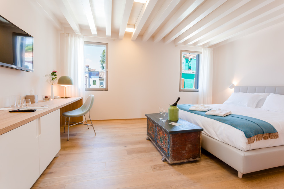 Foto di una camera da letto mediterranea con pareti bianche, parquet chiaro e pavimento marrone