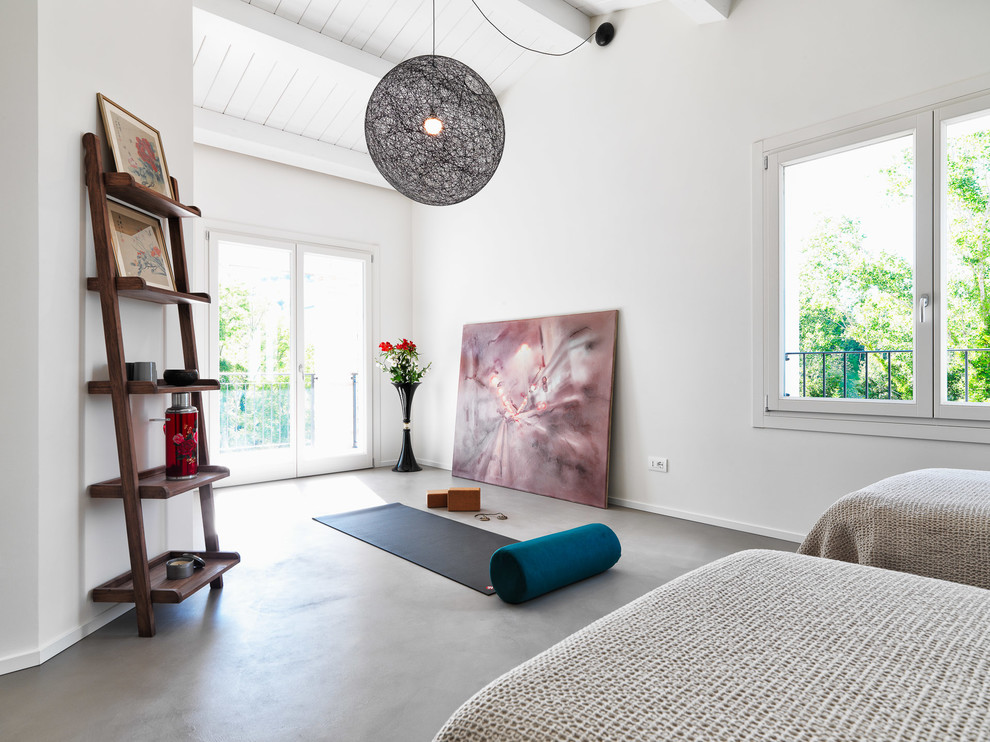 Cette image montre une chambre d'amis design avec un mur blanc, sol en béton ciré, aucune cheminée et un sol gris.