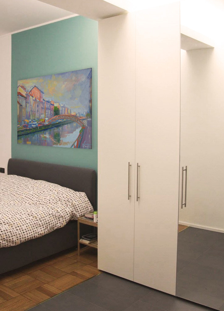 Esempio di una piccola camera matrimoniale contemporanea con pareti blu, pavimento in legno massello medio e pavimento multicolore