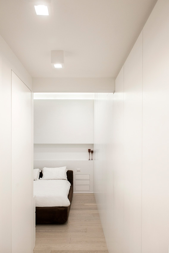 Bedroom - mid-sized contemporary guest medium tone wood floor and brown floor bedroom idea in Rome with white walls