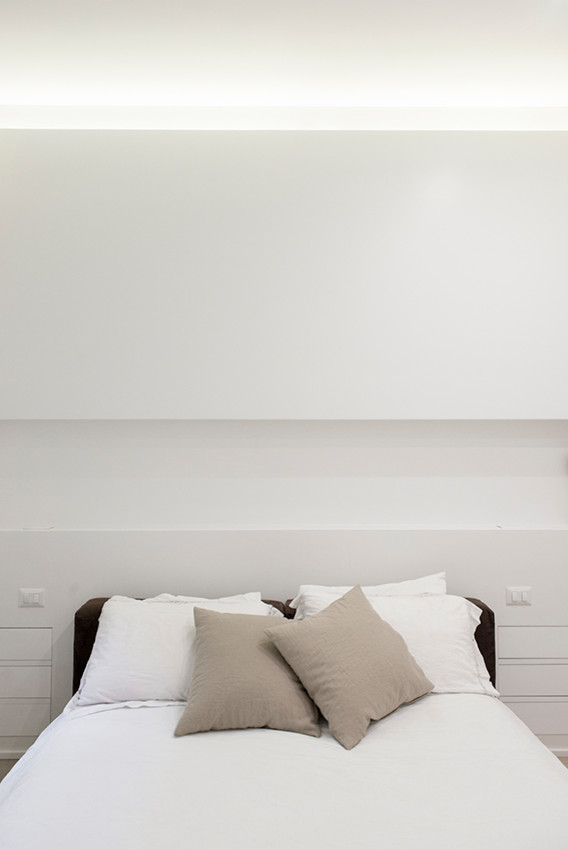 Foto di una camera degli ospiti minimal di medie dimensioni con pareti bianche, pavimento in legno massello medio e pavimento marrone