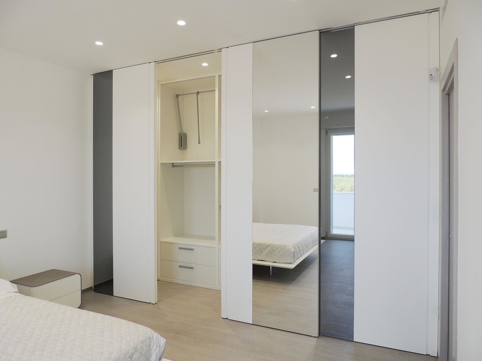 Ejemplo de dormitorio minimalista de tamaño medio con suelo de baldosas de porcelana y suelo gris