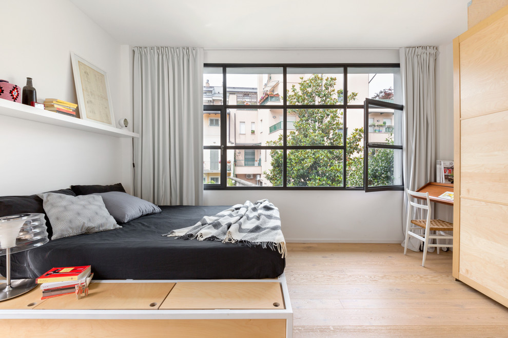 Mittelgroßes Modernes Hauptschlafzimmer mit weißer Wandfarbe, braunem Holzboden und braunem Boden in Mailand