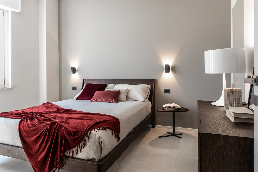 Immagine di una camera da letto design con pareti grigie e pavimento grigio