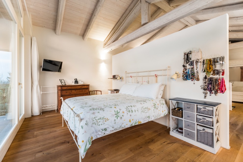 Ejemplo de dormitorio de estilo de casa de campo grande con paredes blancas y suelo de madera en tonos medios