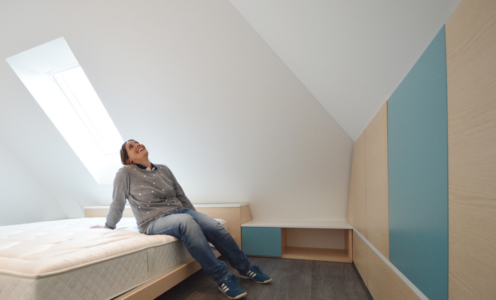 Modelo de dormitorio principal actual de tamaño medio con paredes blancas, suelo de madera oscura y suelo gris