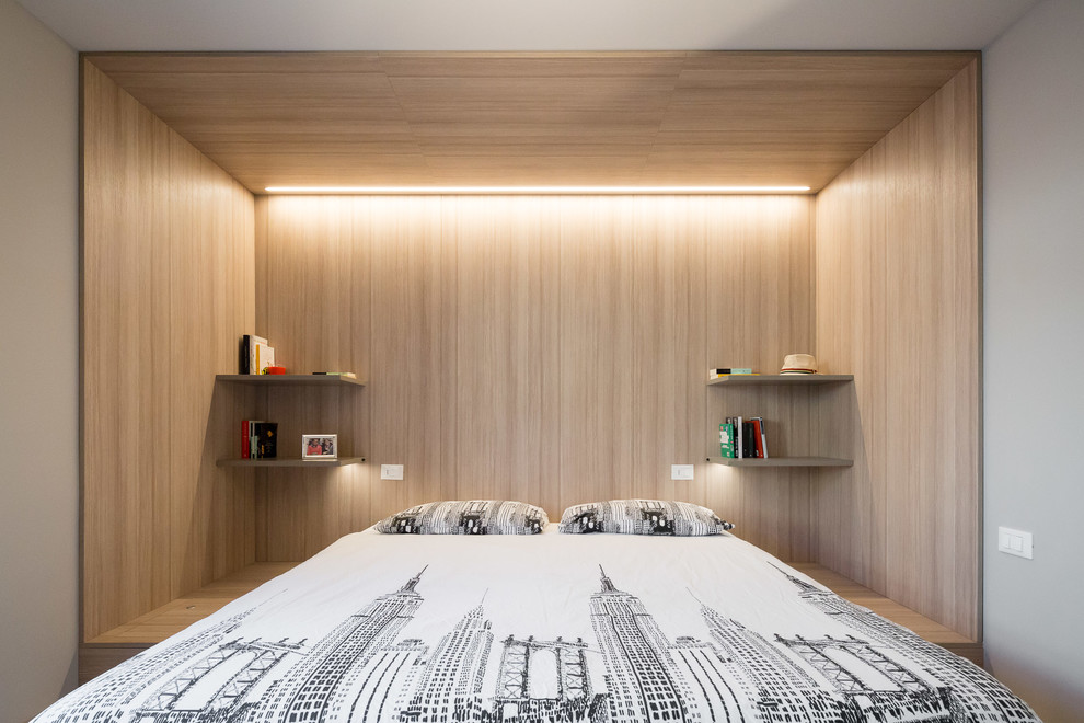Esempio di una piccola camera matrimoniale design con pareti beige, pavimento in legno massello medio e pavimento grigio