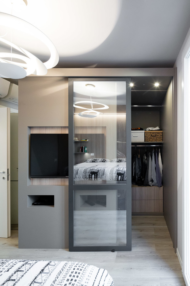 Idee per una piccola camera matrimoniale design con pareti beige, pavimento in legno massello medio e pavimento grigio
