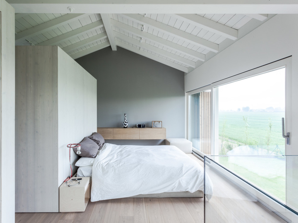 Inspiration för minimalistiska huvudsovrum, med grå väggar och ljust trägolv