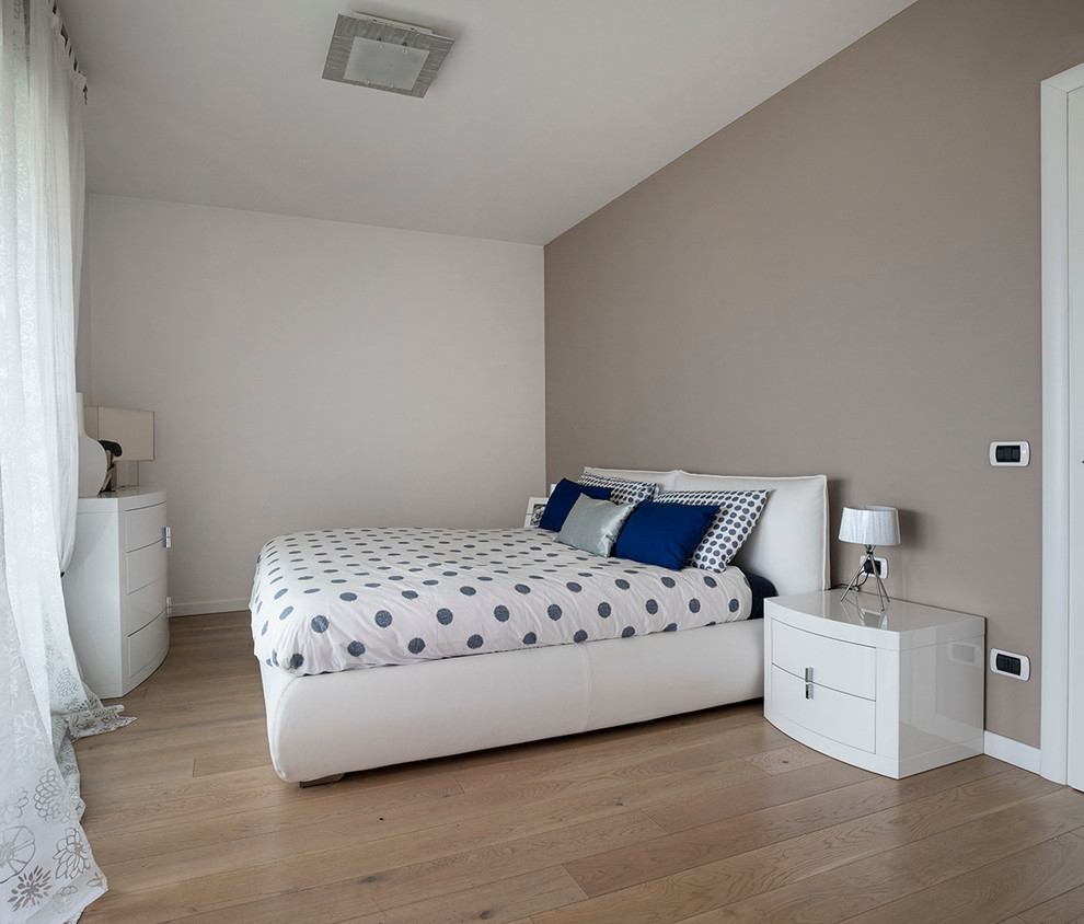 Modelo de dormitorio principal actual de tamaño medio sin chimenea con paredes multicolor y suelo de madera en tonos medios