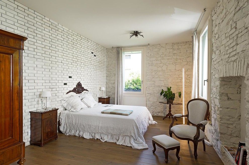 Großes Mediterranes Hauptschlafzimmer ohne Kamin mit weißer Wandfarbe und braunem Holzboden in Mailand