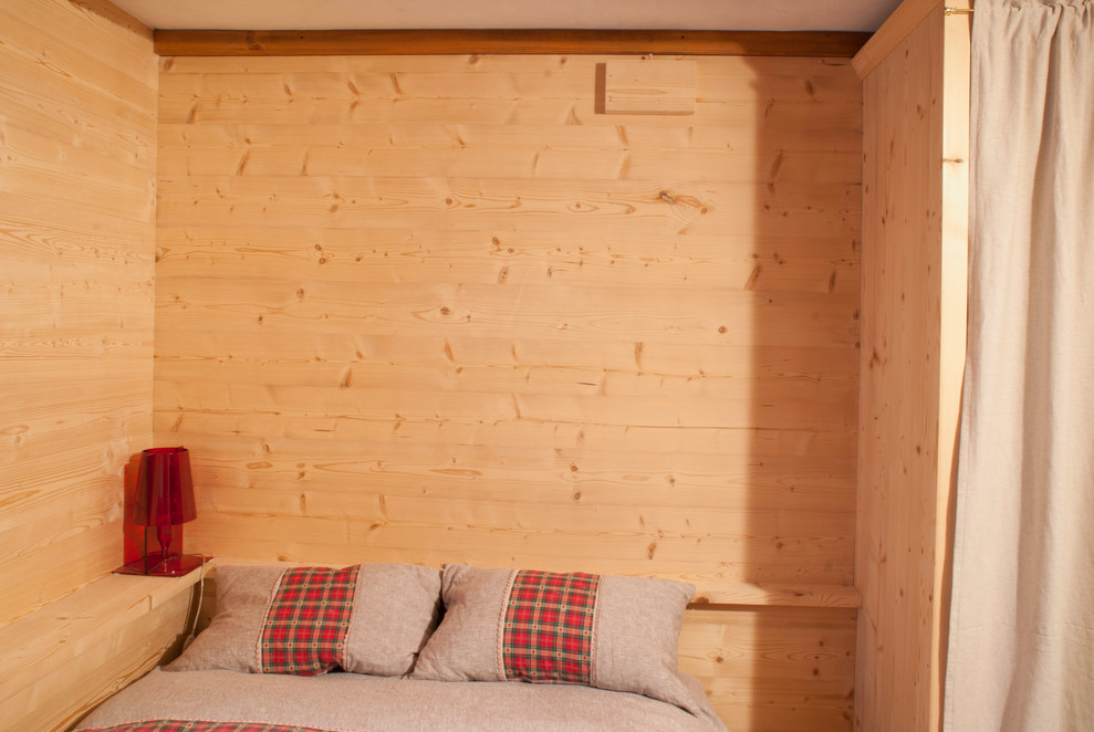 Idée de décoration pour une chambre d'amis chalet de taille moyenne avec un mur marron, un sol en bois brun et un sol marron.