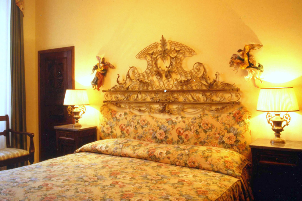Cette image montre une chambre parentale traditionnelle de taille moyenne avec un mur jaune, parquet foncé et un sol marron.