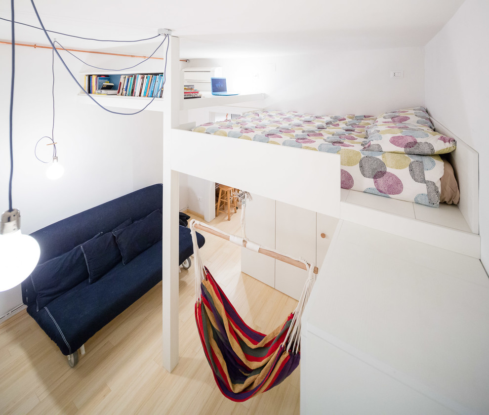 Modelo de dormitorio tipo loft contemporáneo pequeño con paredes blancas y suelo de bambú