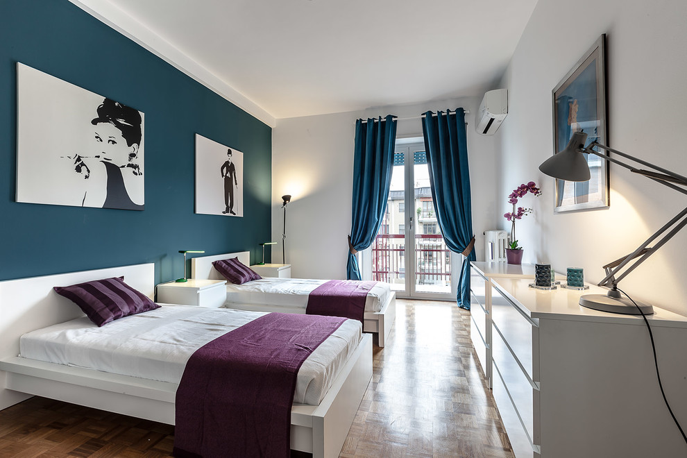 ミラノにあるコンテンポラリースタイルのおしゃれな客用寝室 (青い壁、無垢フローリング、茶色い床、暖炉なし、青いカーテン)