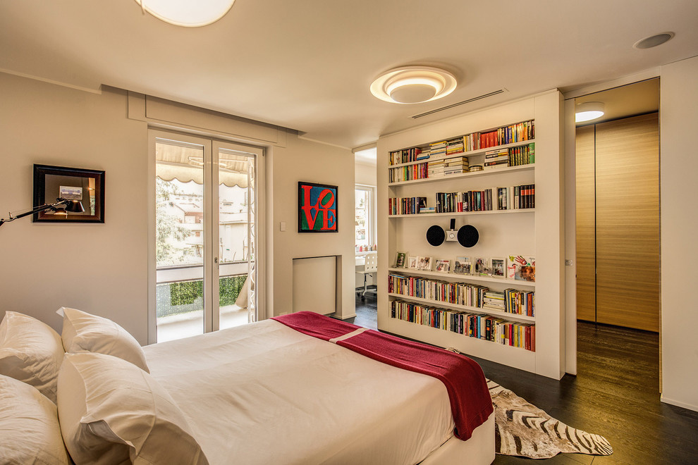 Diseño de dormitorio contemporáneo con paredes blancas, suelo de madera oscura y suelo marrón