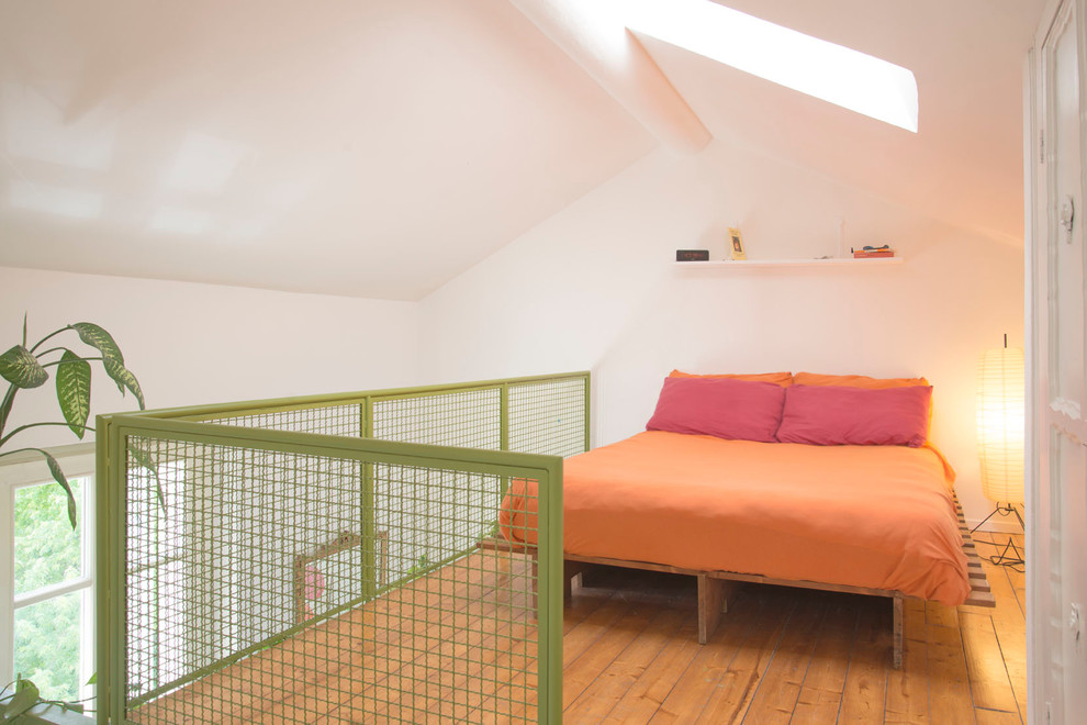 Idée de décoration pour une petite chambre parentale urbaine avec un mur blanc et un sol en bois brun.