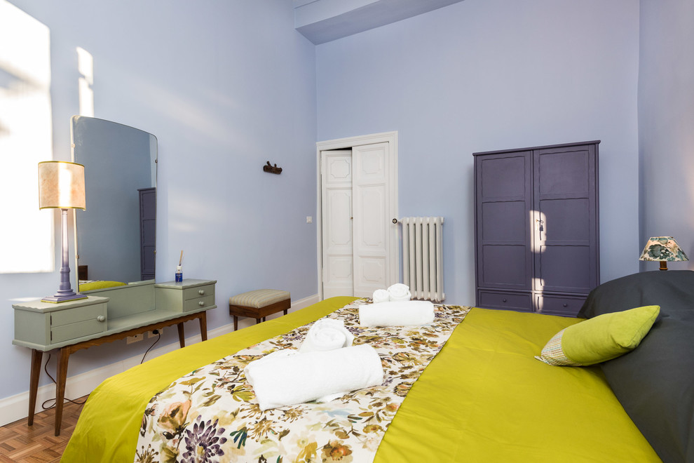 Exempel på ett litet eklektiskt sovrum, med lila väggar, mellanmörkt trägolv och brunt golv