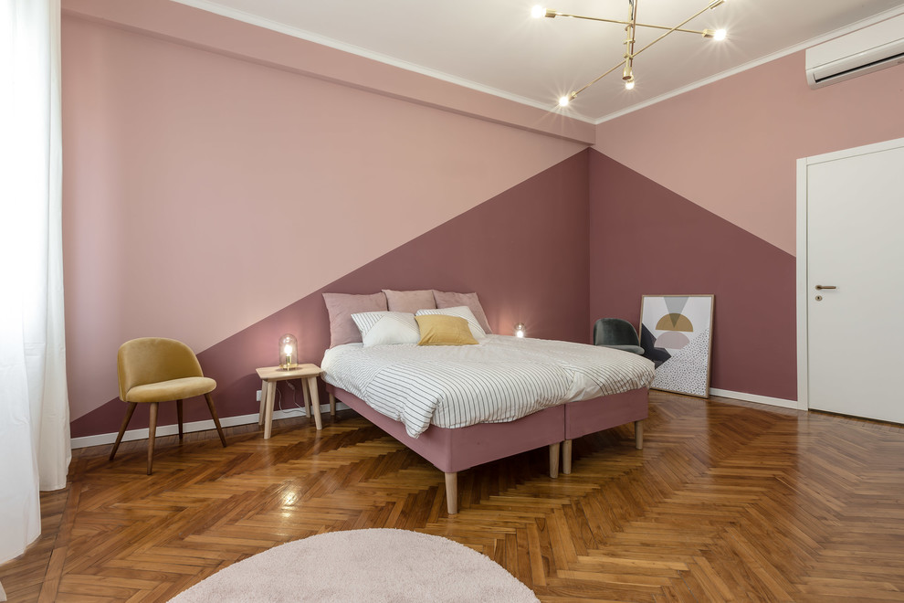 Imagen de dormitorio principal actual de tamaño medio con paredes rosas, suelo marrón y suelo de madera en tonos medios