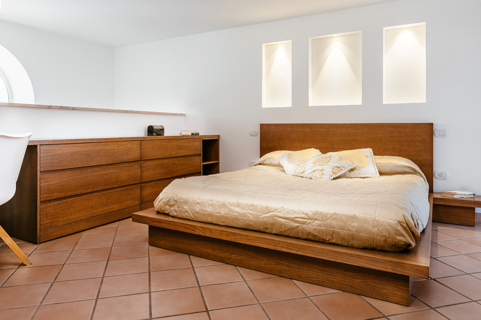 ナポリにあるコンテンポラリースタイルのおしゃれな主寝室 (白い壁、テラコッタタイルの床、茶色い床) のレイアウト