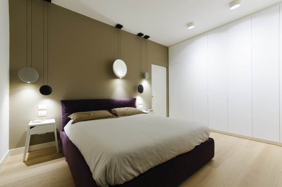 Immagine di una piccola camera matrimoniale contemporanea con pareti multicolore, pavimento in legno massello medio e pavimento beige