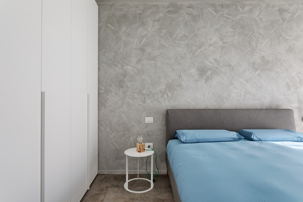 Inspiration pour une chambre parentale design de taille moyenne avec un mur gris et un sol gris.