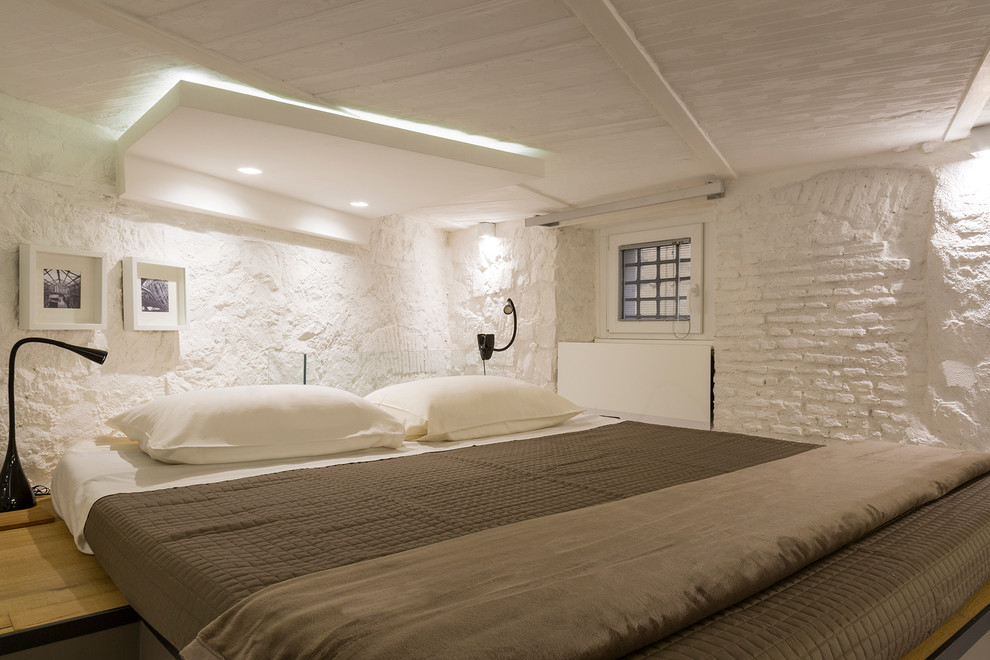 Idée de décoration pour une petite chambre parentale design avec un mur blanc et parquet clair.
