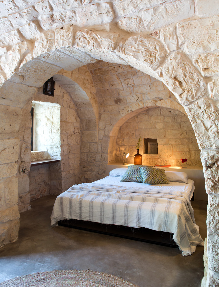 Стильный дизайн: хозяйская спальня в средиземноморском стиле с бетонным полом и серым полом без камина - последний тренд