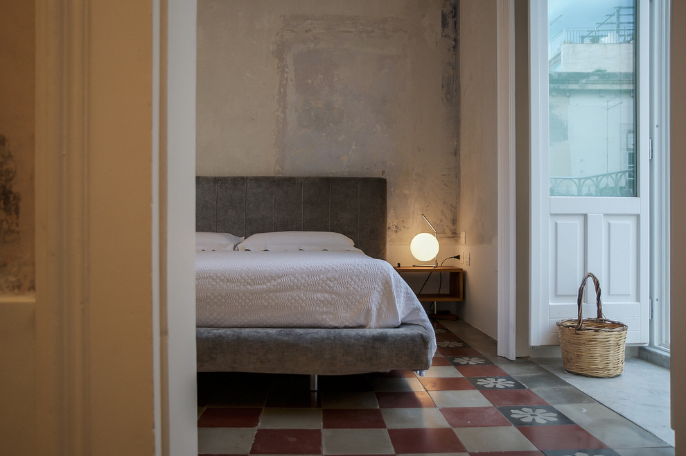 Foto di una camera matrimoniale mediterranea con pareti grigie, pavimento multicolore e pavimento in cemento