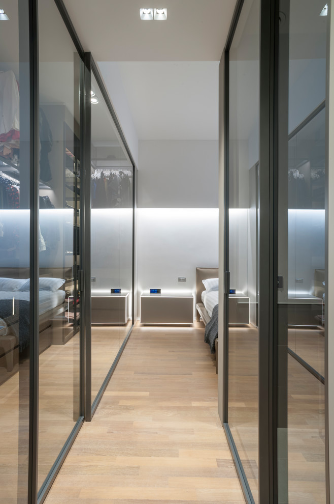 Esempio di una camera matrimoniale minimalista di medie dimensioni con pareti bianche, pavimento in legno massello medio e pavimento marrone