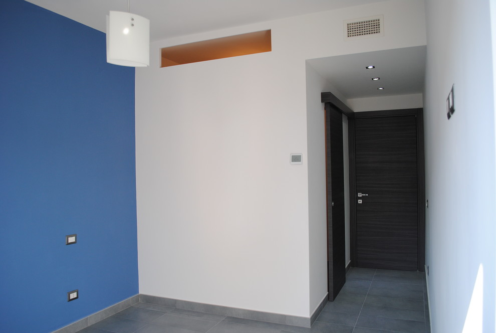 Esempio di una grande camera matrimoniale contemporanea con pareti blu, pavimento in gres porcellanato e pavimento grigio