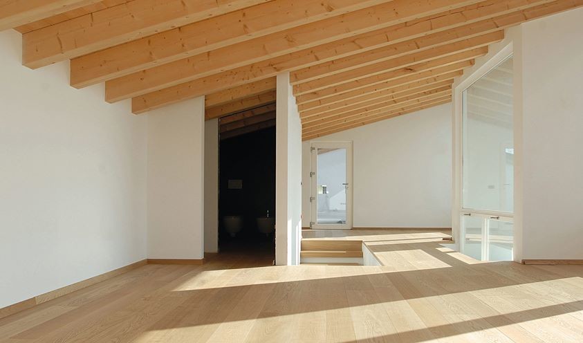 Esempio di una camera da letto stile loft minimal di medie dimensioni con pareti bianche, pavimento in legno massello medio, nessun camino e pavimento marrone