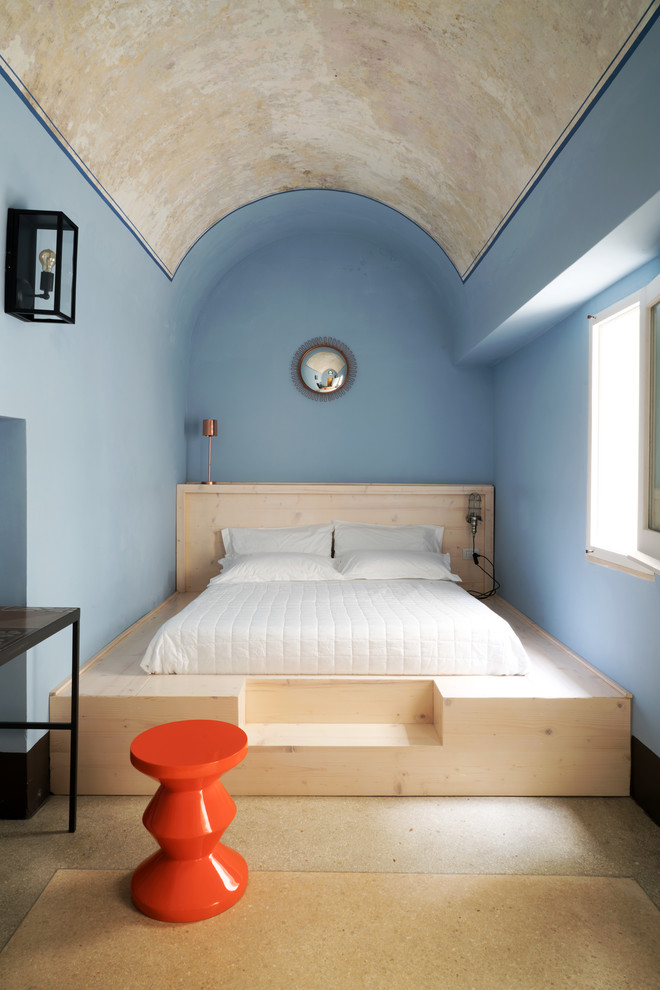Immagine di una camera da letto mediterranea con pareti blu, nessun camino e pavimento beige