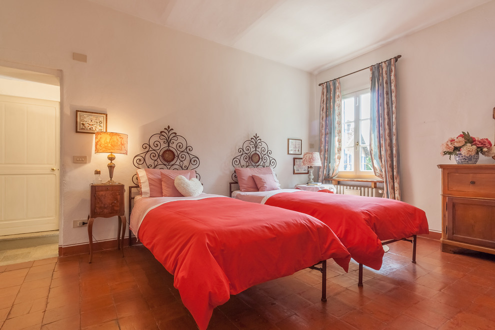 Свежая идея для дизайна: гостевая спальня (комната для гостей) в классическом стиле с белыми стенами, полом из терракотовой плитки и коричневым полом - отличное фото интерьера