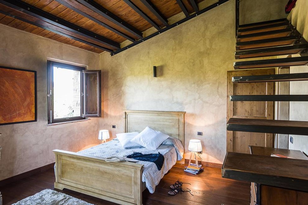 На фото: маленькая хозяйская спальня в стиле кантри с серыми стенами, темным паркетным полом и коричневым полом для на участке и в саду