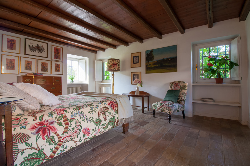Immagine di una camera da letto country con pavimento in terracotta