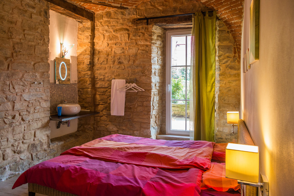 Mittelgroßes Landhausstil Gästezimmer mit braunem Holzboden, bunten Wänden und beigem Boden in Turin