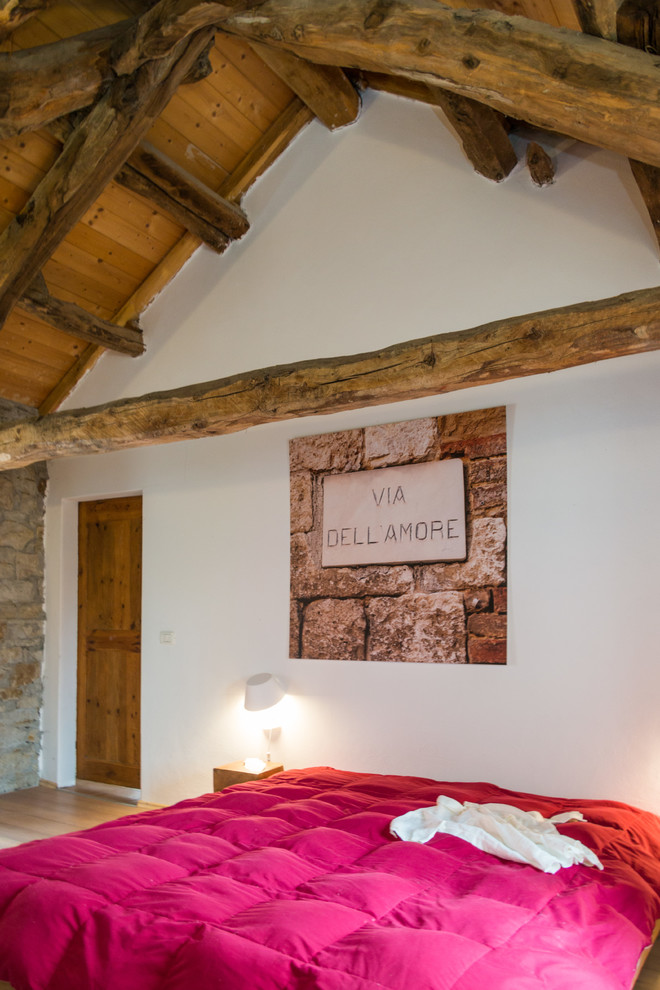 Immagine di una camera degli ospiti minimal di medie dimensioni con pareti bianche e pavimento in legno massello medio