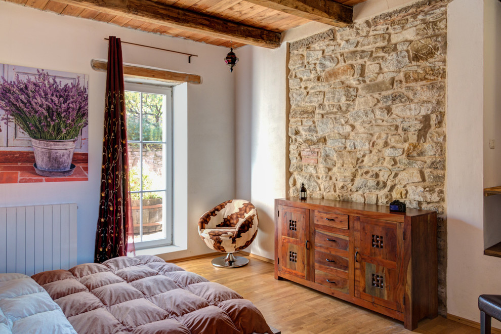 Идея дизайна: гостевая спальня среднего размера, (комната для гостей) в средиземноморском стиле с белыми стенами, паркетным полом среднего тона, коричневым полом и акцентной стеной