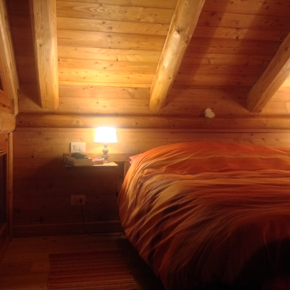 Ejemplo de dormitorio principal rústico de tamaño medio sin chimenea con paredes beige y suelo de madera clara