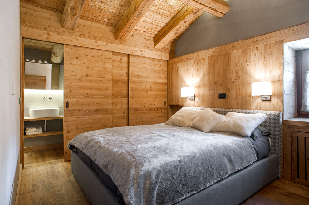 Источник вдохновения для домашнего уюта: хозяйская спальня среднего размера в стиле рустика с серыми стенами и паркетным полом среднего тона без камина