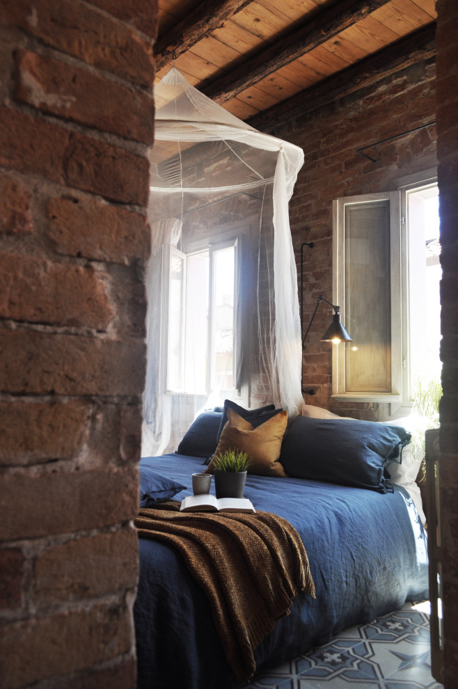 Пример оригинального дизайна: спальня в стиле лофт с красными стенами, разноцветным полом, балками на потолке, деревянным потолком и кирпичными стенами