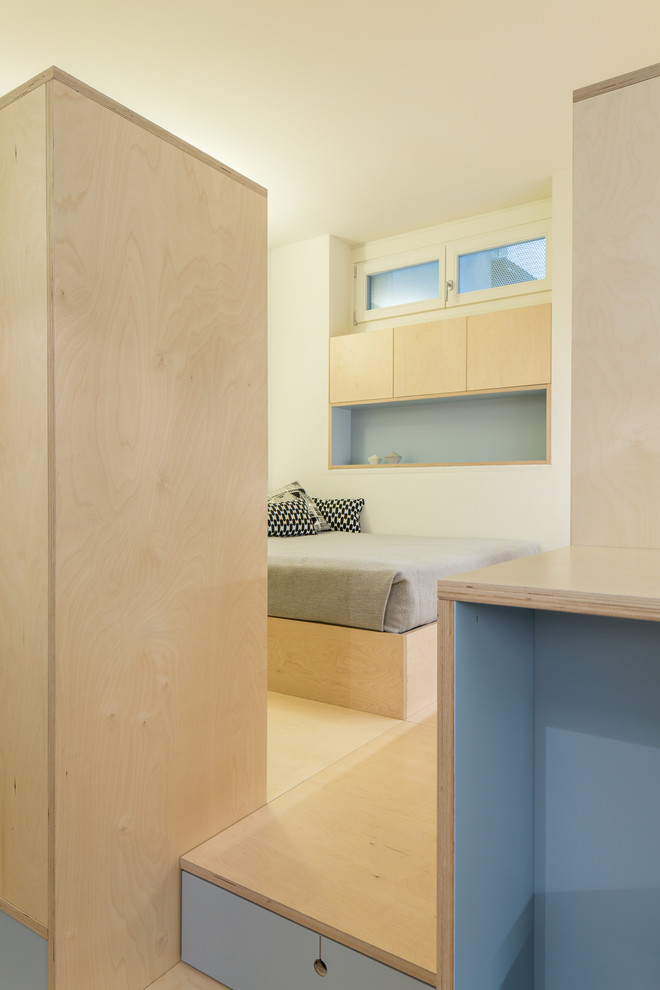 Mittelgroßes Skandinavisches Schlafzimmer im Loft-Style mit weißer Wandfarbe und braunem Holzboden in Mailand
