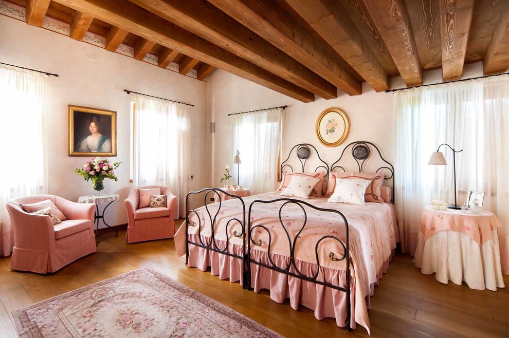 Esempio di una camera da letto chic con pareti bianche, pavimento in legno massello medio e pavimento marrone