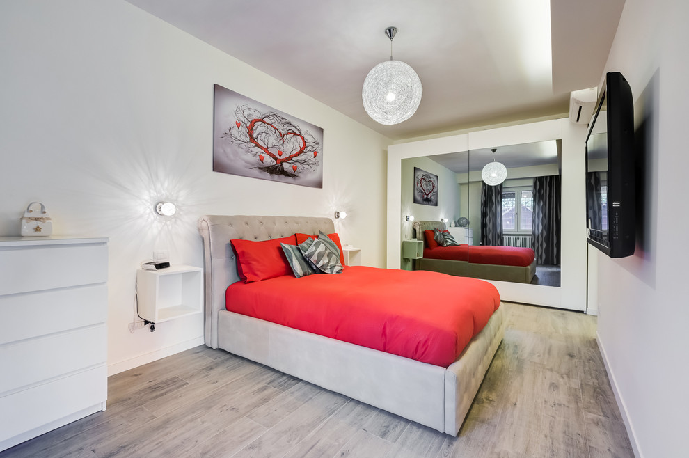 Стильный дизайн: маленькая хозяйская спальня в современном стиле с белыми стенами и полом из ламината для на участке и в саду - последний тренд